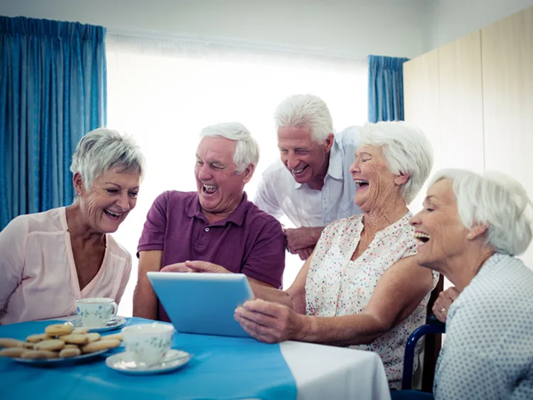 Des aînés réunis autour d’une table partagent un moment convivial